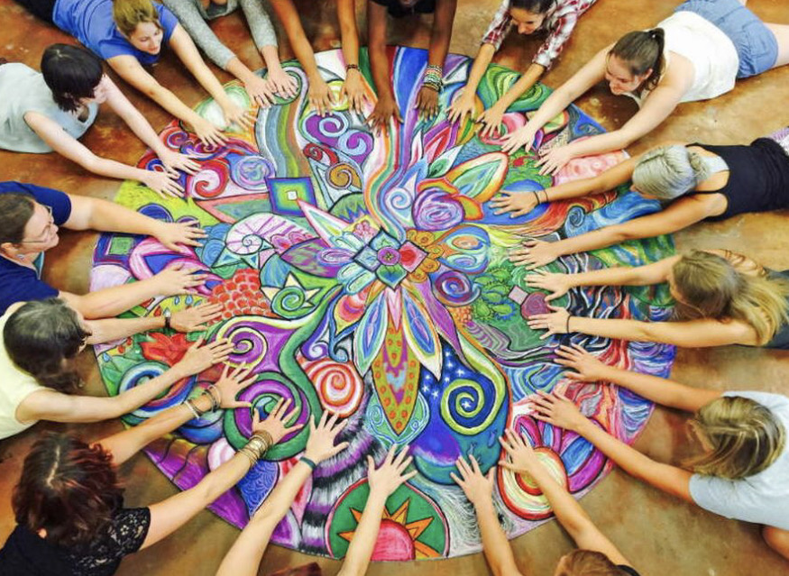 personnes réunies autour d'un mandala géant